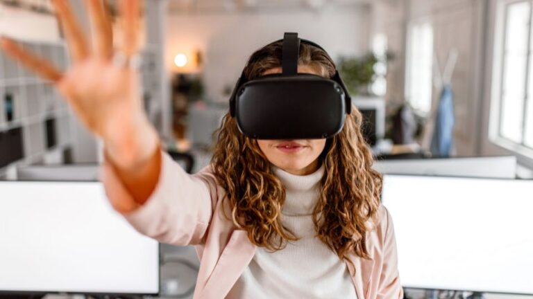 Frau mit Virtual-Reality-Headset in modernem Büro, interagiert mit virtueller Umgebung.